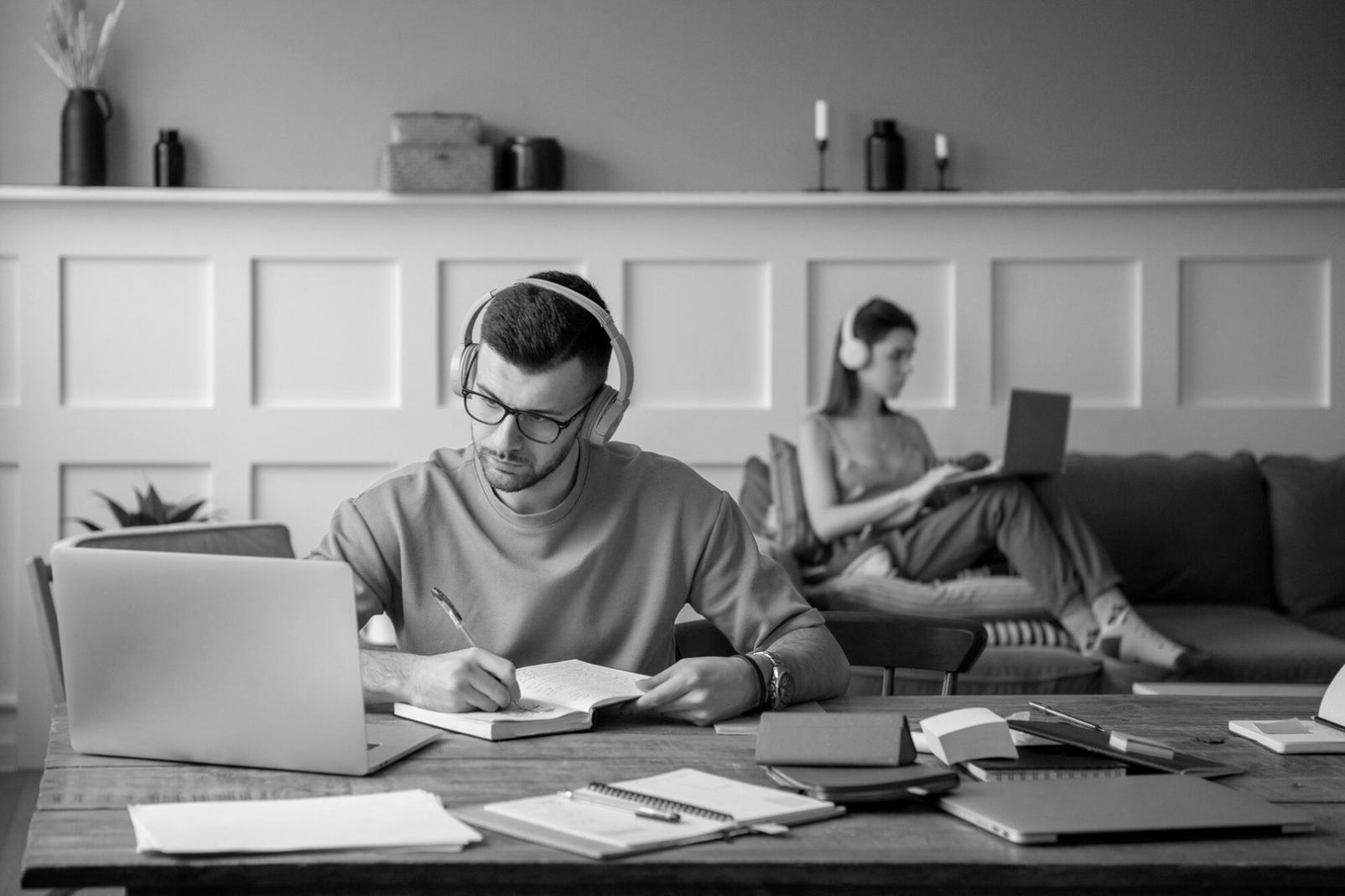 Person arbeitet mit Taschenrechner und Dokumenten am Schreibtisch